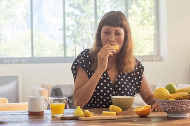 Frau isst Zitrone